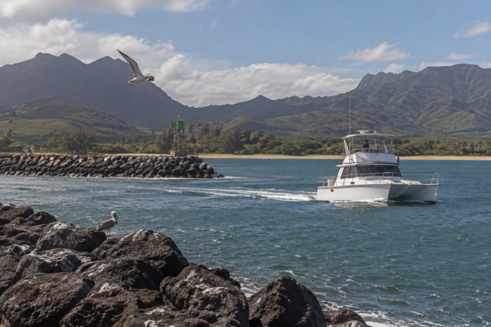 A small boat harbour with a loading dock and moored vessels on Kauai's west side.