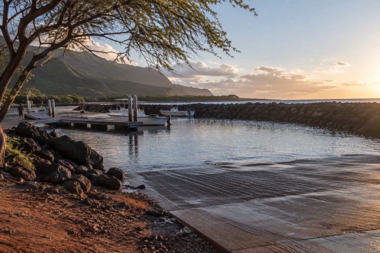A quiet coastal road on Kauai at first light with green cliffs rising above the pavement