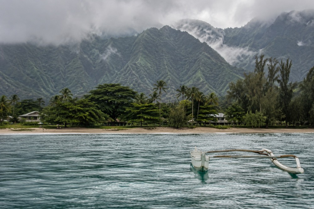 Green ridges above a north shore bay on Kauai with low clouds in the early morning