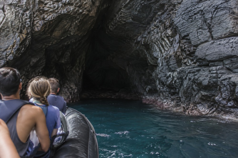 A rigid-hull inflatable raft entering a sea cave on the Napali Coast