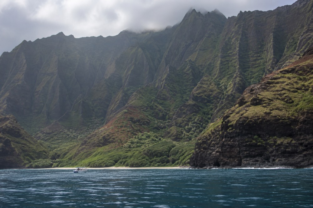 Kalalau Valley seen from the ocean with a boat in the foreground