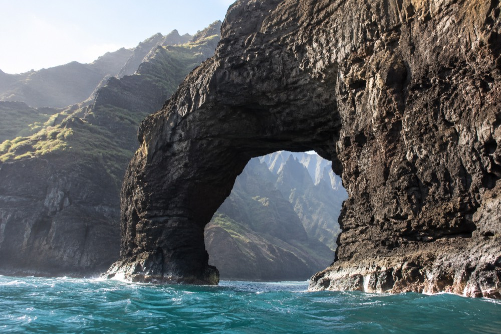 From a low boat angle, the great natural sea arch at Honopu on the Napali Coast
