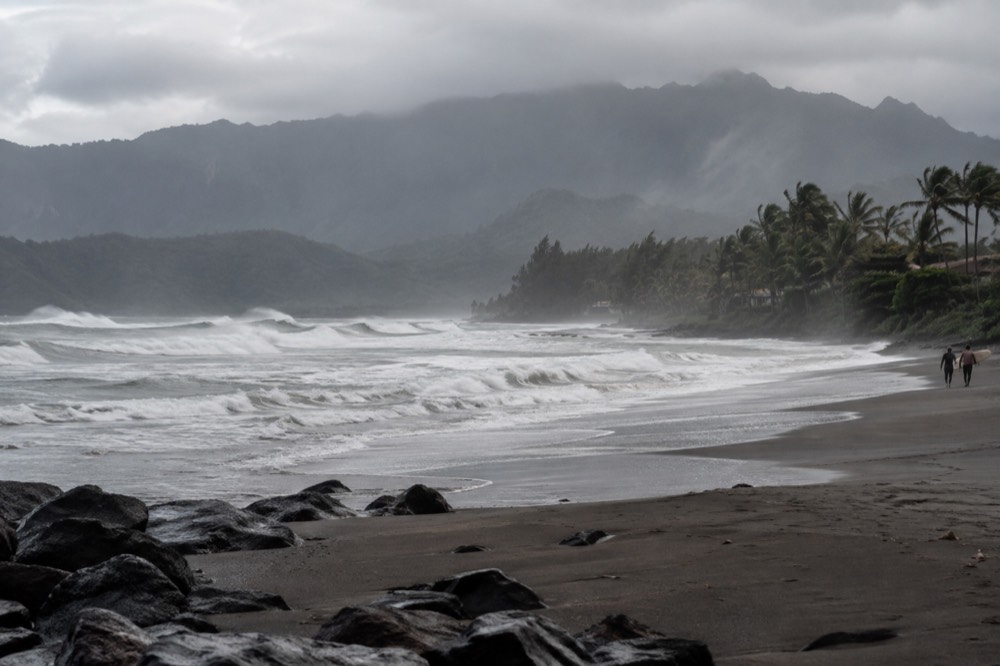 Tall waves breaking across a north-facing bay under a grey winter sky.