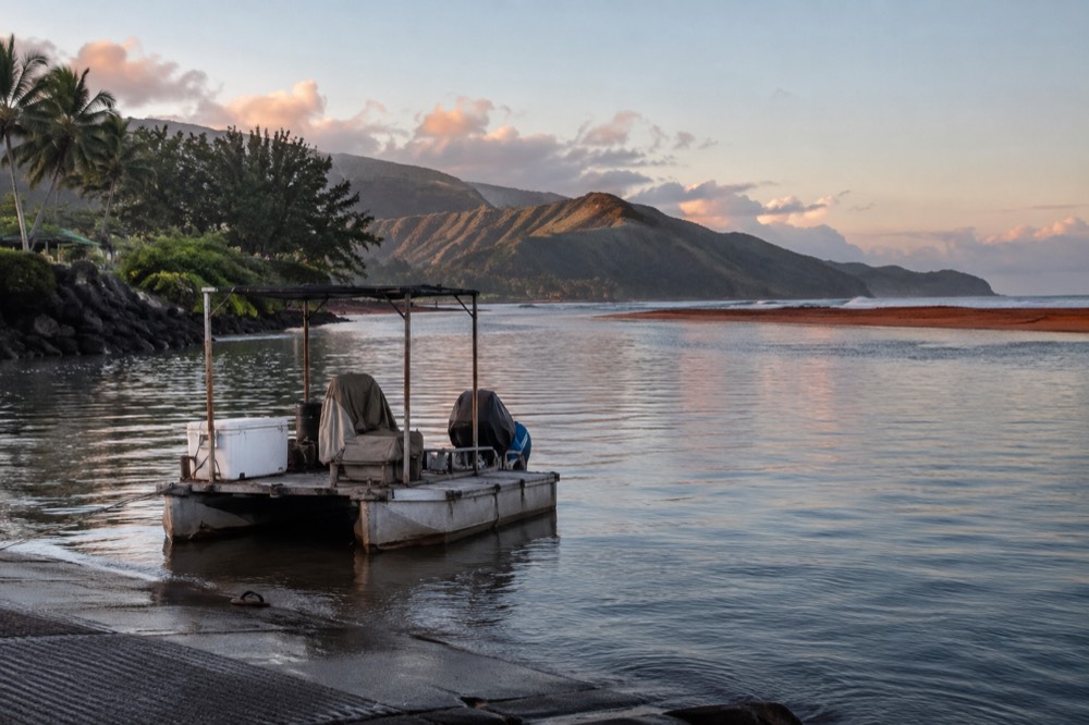 A small boat harbour on Kauai with moored vessels and calm morning water