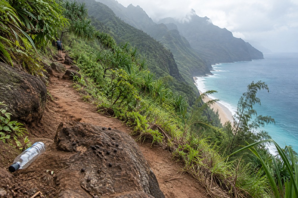 The Kalalau Trail winding along a green coastal ridge above the ocean