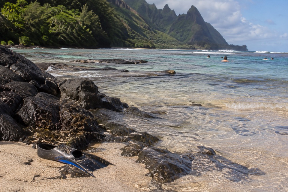 A sandy beach with clear shallow water over a nearshore coral reef
