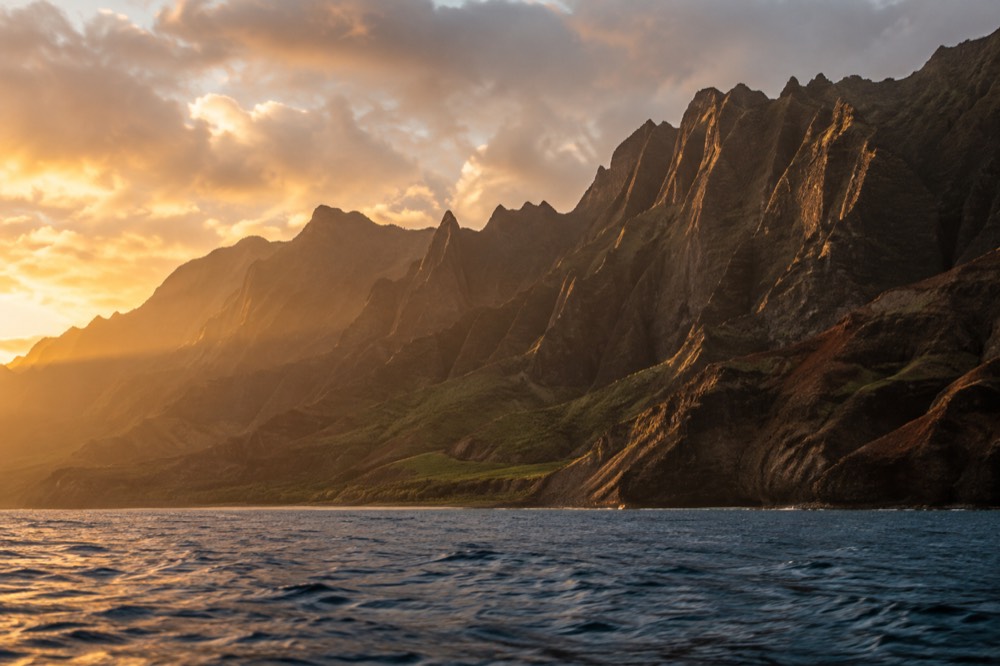 Golden sunset light on Napali cliffs seen from open water