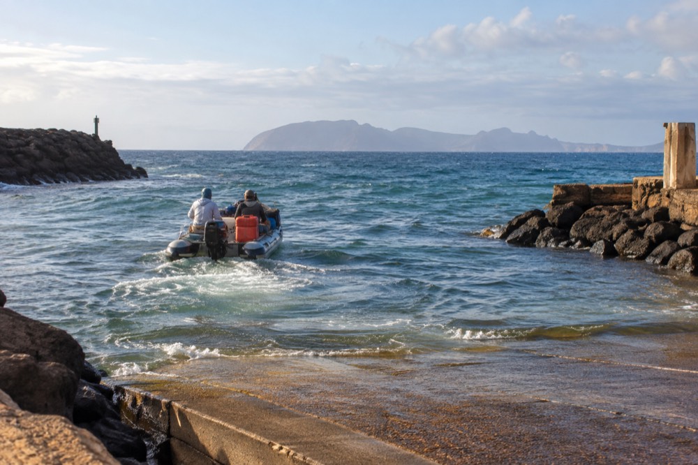 A Niihau-bound raft pushes across open swell off Kauai's west shore