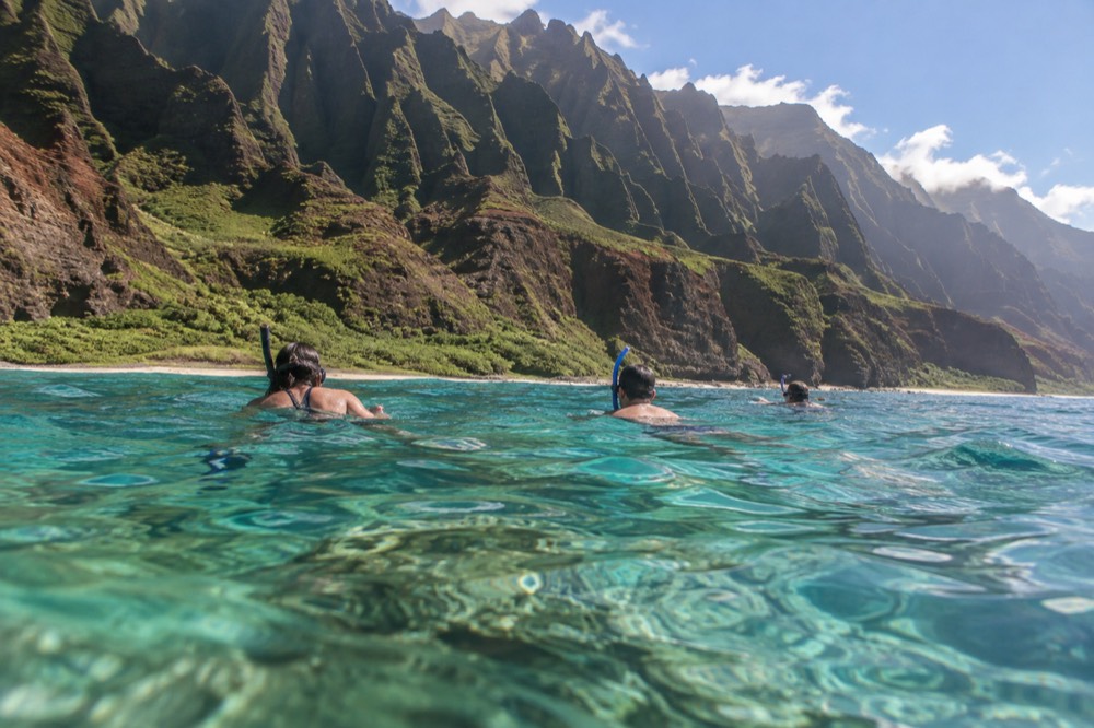 Snorkelers from a permitted raft tour float over the shallow reef shelf at Nualolo Kai