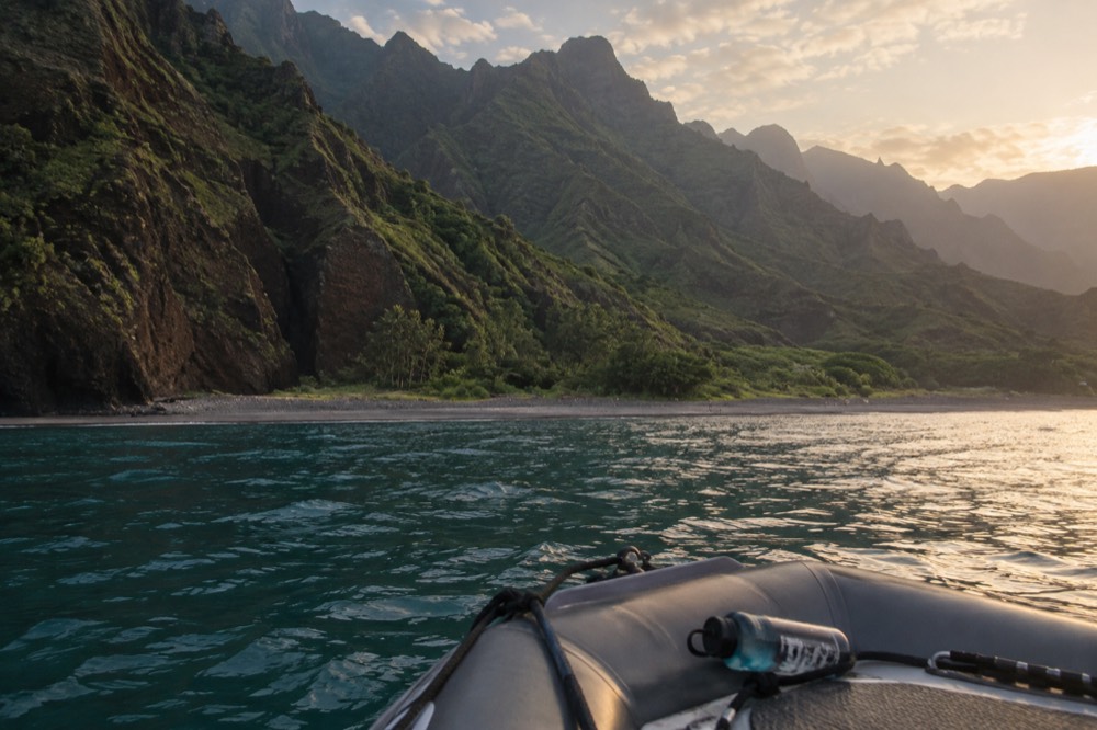 A shallow-drafted raft holding position just off the sand at Miloli'i Beach on the Napali Coast