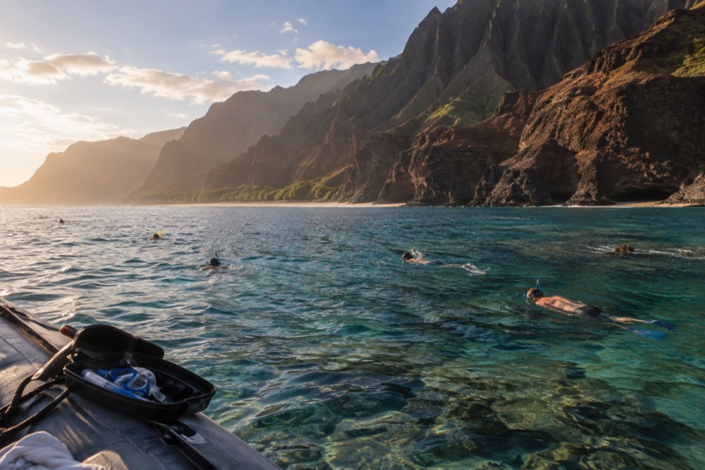Snorkelers scattered over the reef shelf off Nualolo Kai