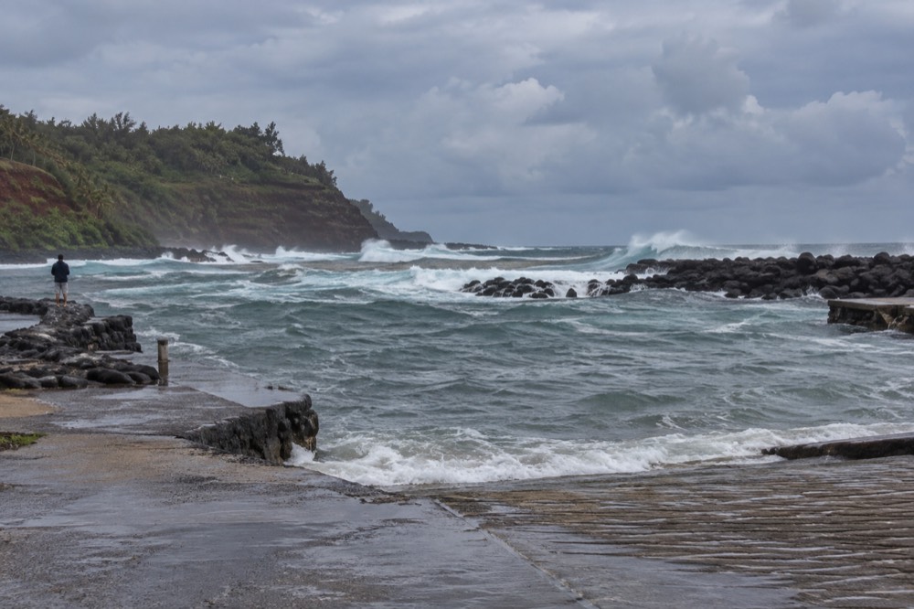 February storm swell surges grey and choppy across the open water near Kikiaola Small Boat Harbor on Kauai's west
