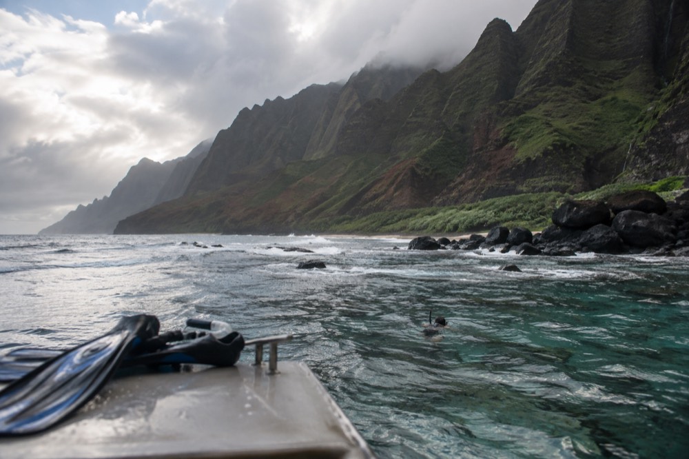 A shallow reef flat lies ruffled by leftover winter swell off Nualolo Kai on Kauai's Napali Coast