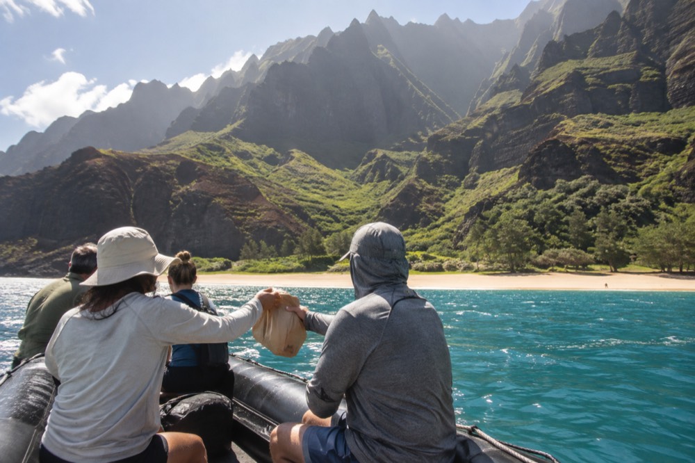 A rigid inflatable raft holds off the golden sand at Miloli'i Beach on Kauai