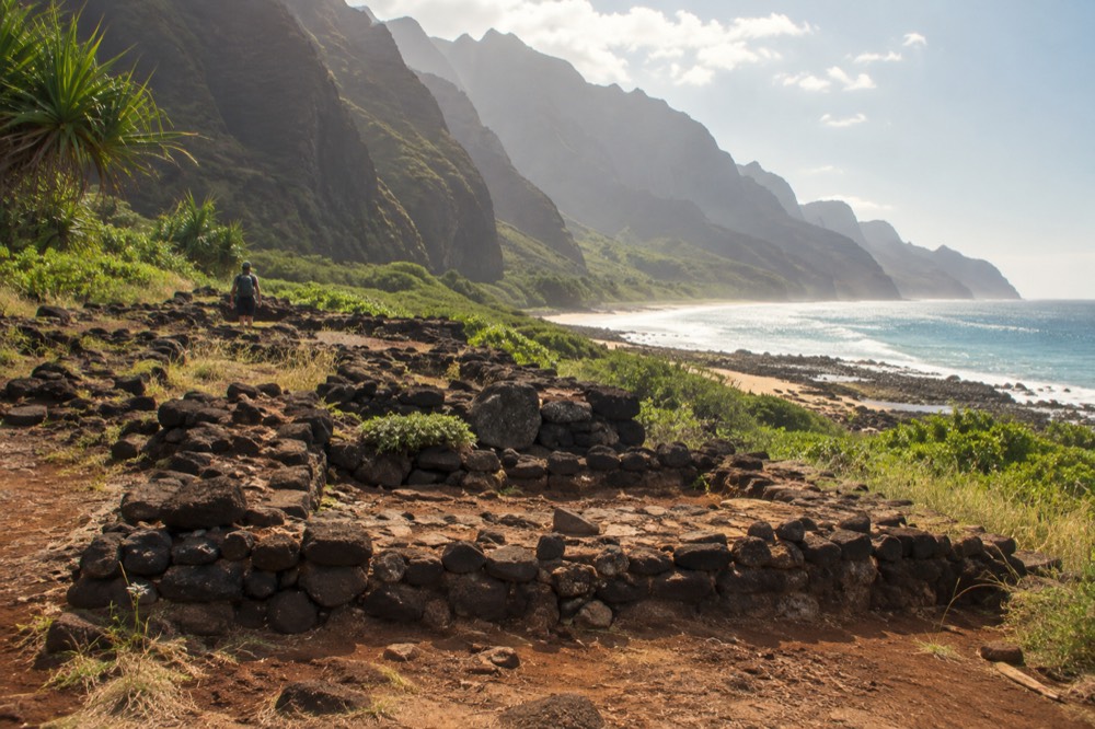 Stone terraces and reef fringing a narrow beach beneath high sea cliffs